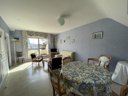 un salon avec une table et des chaises dans une pièce dans l'établissement Appartement avec Balcon à 500m de la Plage et Proche Commerces à Jullouville - FR-1-361-489, à Jullouville