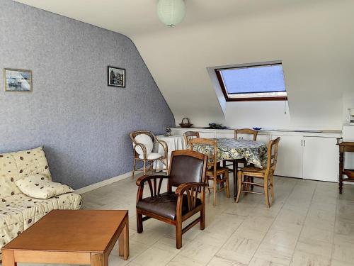un salon avec un canapé, une table et des chaises dans l'établissement Appartement avec Balcon à 500m de la Plage et Proche Commerces à Jullouville - FR-1-361-489, à Jullouville