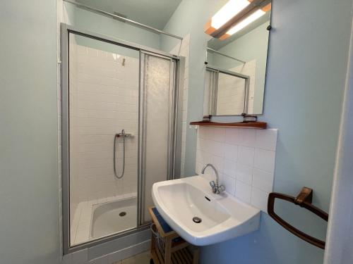 une salle de bain blanche avec un lavabo et une douche dans l'établissement Appartement avec Balcon à 500m de la Plage et Proche Commerces à Jullouville - FR-1-361-489, à Jullouville