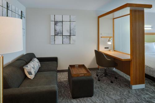 a hotel room with a couch and a desk and a bed at SpringHill Suites by Marriott Bloomington in Bloomington