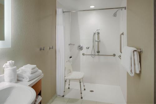 a bathroom with a shower and a toilet and a sink at SpringHill Suites by Marriott Bloomington in Bloomington