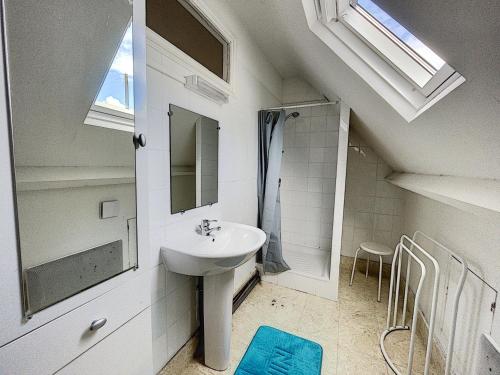 une salle de bain blanche avec un lavabo et une douche dans l'établissement Maison avec jardin clos, à 600m de la plage, 4 chambres, barbecue, proche commerces et attractions - FR-1-361-495, à Jullouville