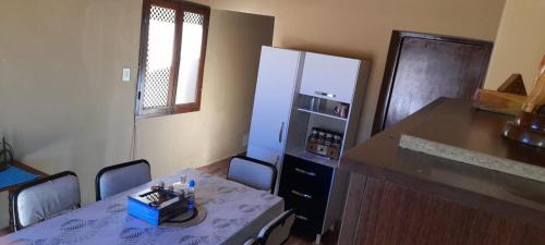 a kitchen with a table with chairs and a refrigerator at Cabaña la Encantada in Humahuaca