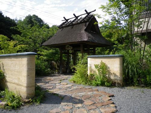 龜岡的住宿－Ryokan Sumiya Kihoan，花园内的一个凉亭,花园内设有石路