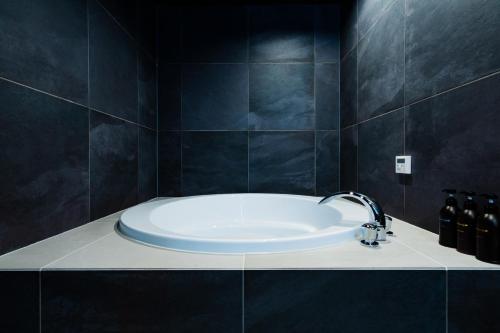 a bathroom with a bath tub with a sink at Randor Hotel Hiroshima Prestige in Hiroshima