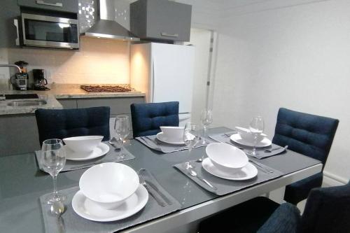 uma mesa com pratos e copos de vinho em Disfruta de cómodo y bello departamento em Guadalajara