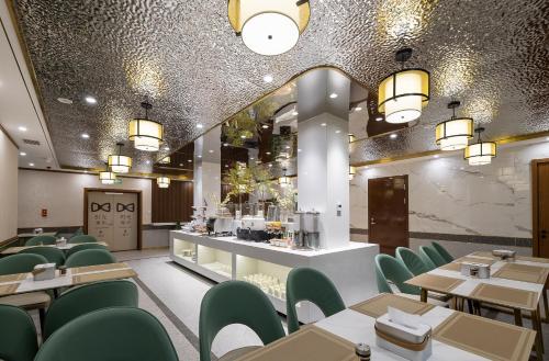 a restaurant with green chairs and tables and a counter at Nostalgia S Hotel Beijing National Convention Center 时光漫步S酒店北京国家会议中心店 Free fresh ground coffee,Free laundry service in Beijing