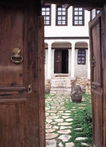 an open door to a house with a stone yard at Vergoula's Mansion in Kastoria