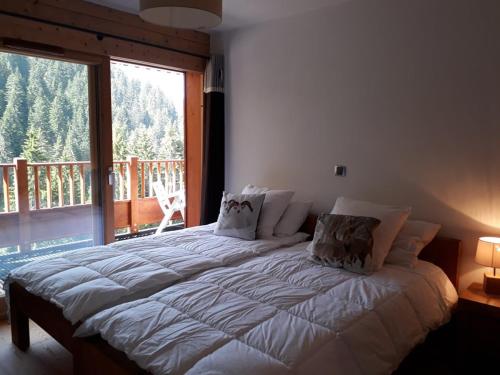 a large bed in a bedroom with a large window at Appartement 8 personnes, piscine, wifi, 4 ch, parking - FR-1-733-123 in Crest-Voland