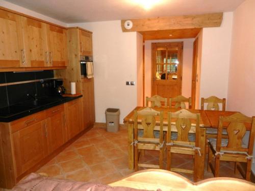 une cuisine avec une table et des chaises dans une pièce dans l'établissement Appartement cosy 6 pers, balcon, piscine couverte, garage, Crest-Voland - FR-1-733-124, à Crest-Voland