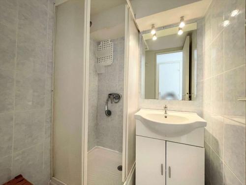 une salle de bain avec un lavabo, une douche et un miroir dans l'établissement Studio mezzanine climatisé avec piscine, terrasse, parking privé et proche plage - Gruissan - FR-1-229-861, à Gruissan