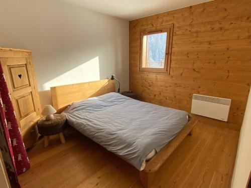 une chambre avec un lit dans une pièce en bois dans l'établissement Appartement 3 pièces avec piscine et parking, jusqu'à 6 personnes - FR-1-733-128, à Crest-Voland