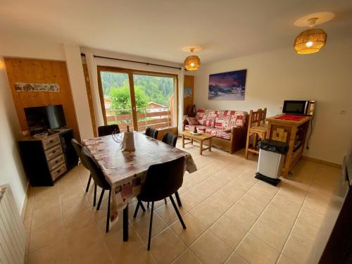 une cuisine et un salon avec une table et des chaises dans l'établissement Charmant T2 + cabine avec balcon orienté sud à Saint-Jean-de-Sixt, proche de La Clusaz - FR-1-459-209, à Saint-Jean-de-Sixt
