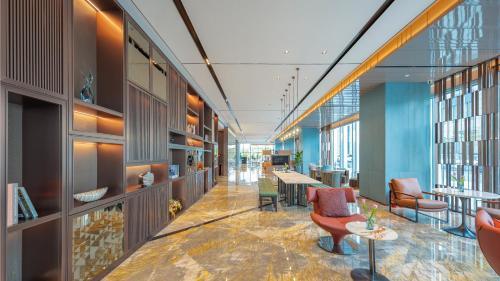 a lobby of a building with chairs and tables at Holiday Inn Changchun Oriental Plaza by IHG in Changchun