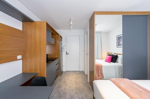 een hotelkamer met 2 bedden en een keuken bij Housi Brickell One Com Vaga - HBO0606 V12 in Curitiba