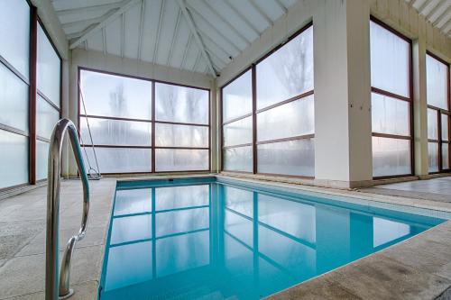 una piscina en una casa con ventanas en Terrazas Bariloche vista en San Carlos de Bariloche