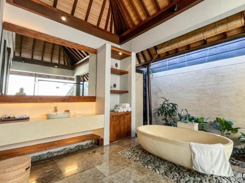 a bathroom with a tub and a sink at Villa Canthy@Seminyak in Seminyak