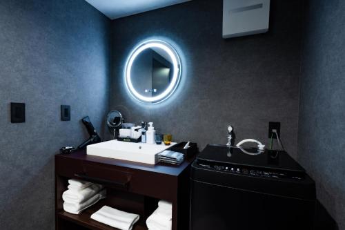 a bathroom with a sink and a mirror at Randor Hotel Hiroshima Prestige in Hiroshima