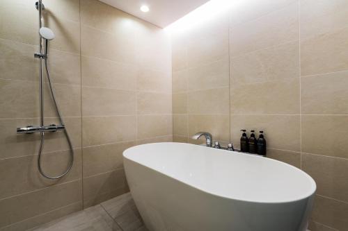 a bathroom with a white tub and a shower at Randor Hotel Hiroshima Prestige in Hiroshima