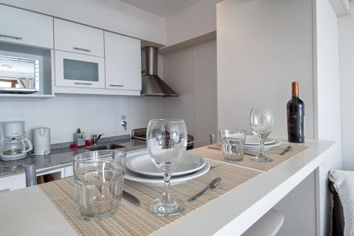 a kitchen with a table with wine glasses on it at Bariloche vista al lago, piscina, pleno centro in San Carlos de Bariloche