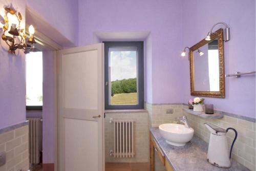 een paarse badkamer met een wastafel en een spiegel bij Villa Orte in Orte