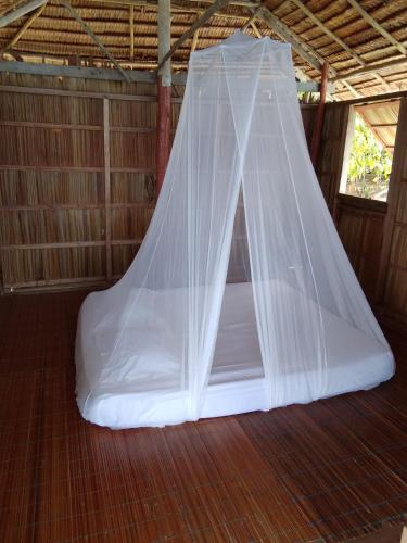 a bed with a net in a tent at Daroyen Village in Kri