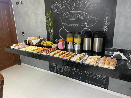 a counter with a bunch of pastries and aasteryasteryasteryasteryasteryastery at Pousada Elegance Beira Mar in Itanhaém