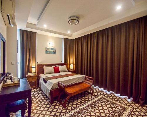 ein Hotelzimmer mit einem Bett und einem Klavier in der Unterkunft Andy's Place in Siem Reap