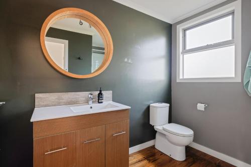 une salle de bain avec un lavabo, des toilettes et un miroir dans l'établissement Aloha Haven, à Ventnor