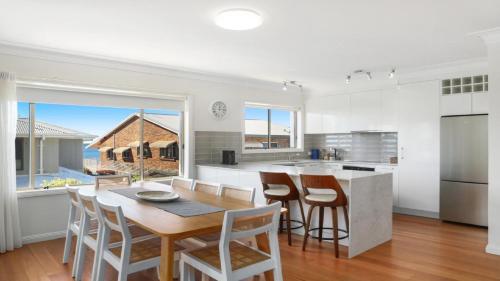 a kitchen and dining room with a table and chairs at Moon Glow Views, Short Walk To Beach Accom Holidays in Terrigal
