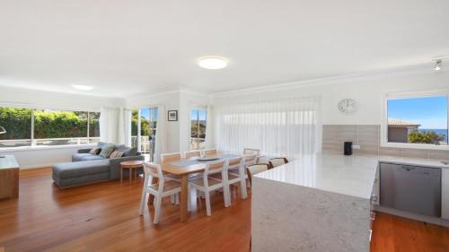 a kitchen and living room with a table and chairs at Moon Glow Views, Short Walk To Beach Accom Holidays in Terrigal