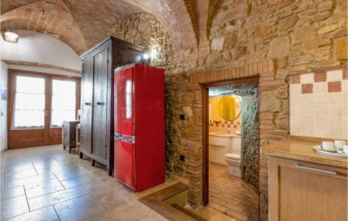 einen roten Kühlschrank in einer Küche mit einer Steinmauer in der Unterkunft Amazing Home In Mazzolla With Wifi in Mazzolla