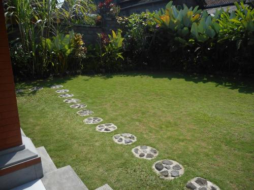 a garden with rocks laid out on the grass at Cegeng Lestari Guesthouse in Sidemen