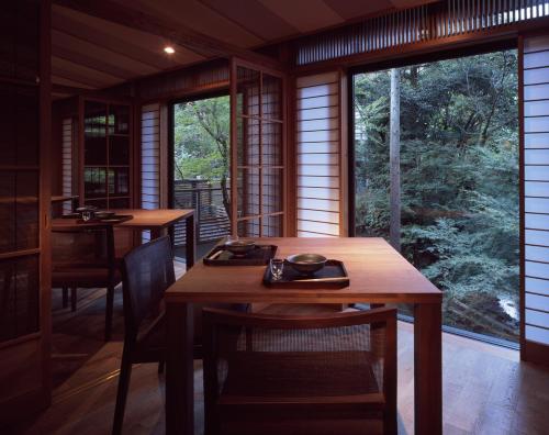 a dining room with two tables and a large window at Ryokan Sumiya Kihoan in Kameoka