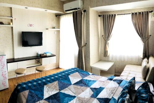 una camera con letto, TV e finestra di Margonda Residence By Ensroom id a Kemirimuka Dua