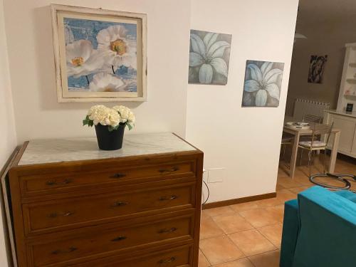 a dresser with a vase of flowers on top of it at Appartamento Antonietta- in Santa Maria degli Angeli