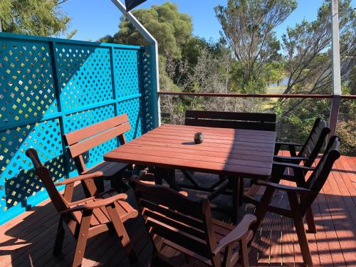 a wooden table and chairs on a deck at Sail House overlooking Lancelins main park in Lancelin