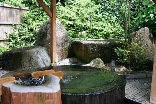 a water fountain in a garden with rocks at Ryokan Sumiya Kihoan in Kameoka