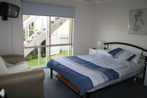 Un dormitorio con una cama y un sofá y una ventana. en The Waters Edge at Tampa, en Cape Woolamai
