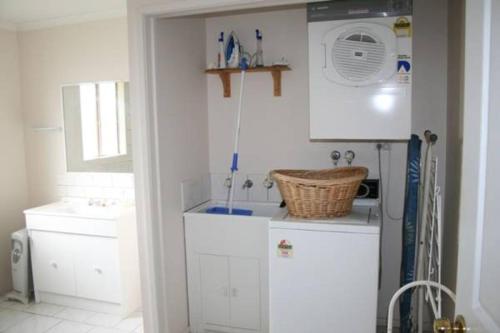 Una cocina con un refrigerador blanco y un fregadero. en The Waters Edge at Tampa, en Cape Woolamai