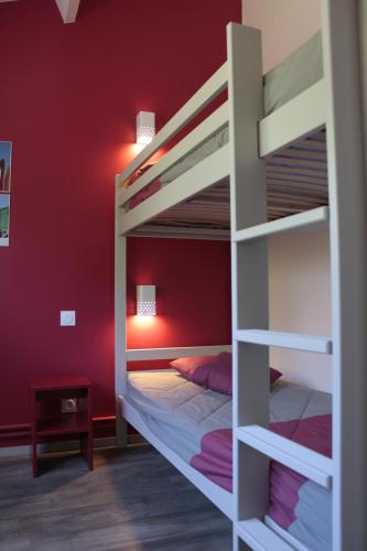 - une chambre avec 2 lits superposés et un mur rouge dans l'établissement VVF La côte d'Emeraude Saint-Cast-le-Guildo, à Saint-Cast-le-Guildo