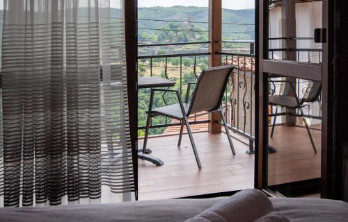 een kamer met een balkon met een tafel en stoelen bij Family House Atanasovi in Veliko Tŭrnovo