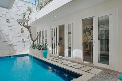 a house with a swimming pool next to a building at The Wina Villa Canggu in Canggu