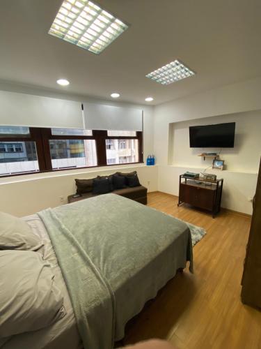 a bedroom with a bed and a flat screen tv at Vai ser feliz in Rio de Janeiro