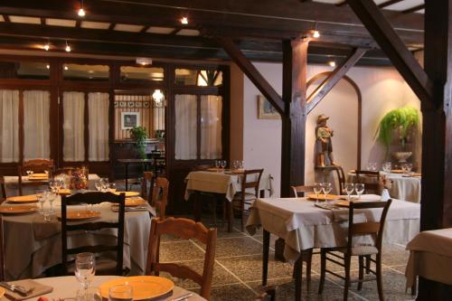 une salle à manger avec des tables et des nappes blanches dans l'établissement Castel Hotel 1904, à Saint-Gervais-dʼAuvergne