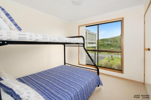 ein Schlafzimmer mit einem Etagenbett und einem Fenster in der Unterkunft 11 Glen Street in Surf Beach