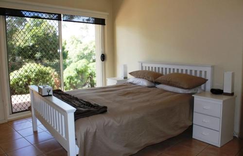 une chambre avec un grand lit et une grande fenêtre dans l'établissement The Waves Oasis, à Cowes