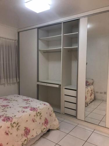 a bedroom with a bed and a glass closet at Canal 3 Living - Hospedagem Aconchegante em Santos in Santos