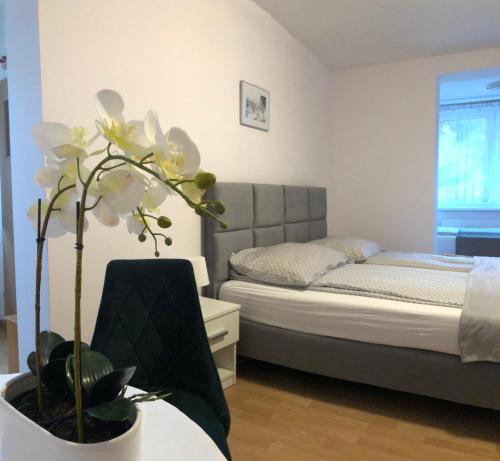 Un dormitorio con una cama y una mesa con una planta en Villa Ola, en Polanica-Zdrój