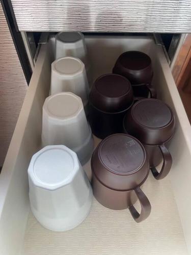 a drawer filled with different types of pots and pans at NAMIOTO Kumano-Kodo Beachfront Rental House in Kumano